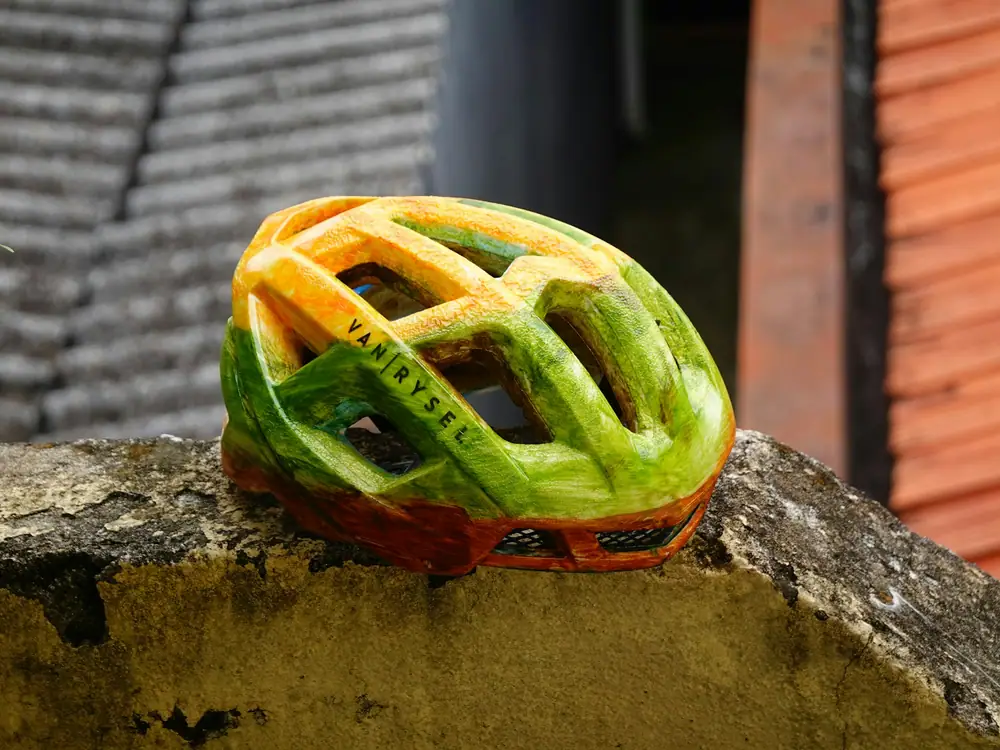 A ventilated cycling helmet resting on a stone wall